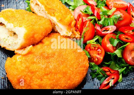 Chicken Kiev Cutlet mit frischem Gemüsesalat.Ukrainisches Essen Stockfoto