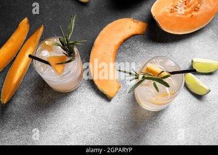 Gläser mit kaltem Cocktail, Melone und Limette auf schwarzem und weißem Hintergrund Stockfoto