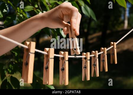 Frau hängen Wäscheklammern auf Wäscheleine im Freien Stockfoto
