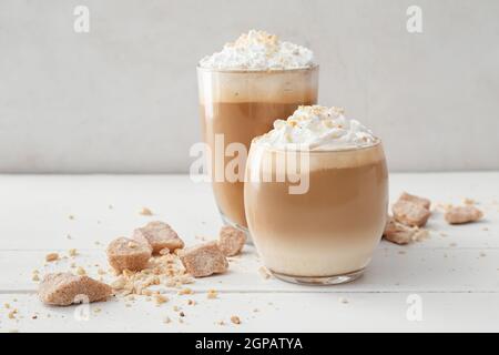 Gläser mit leckeren Latte mit Nüssen auf dem Tisch Stockfoto