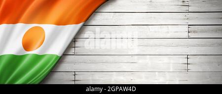 Niger-Flagge auf alter weißer Mauer. Horizontales Panorama-Banner. Stockfoto