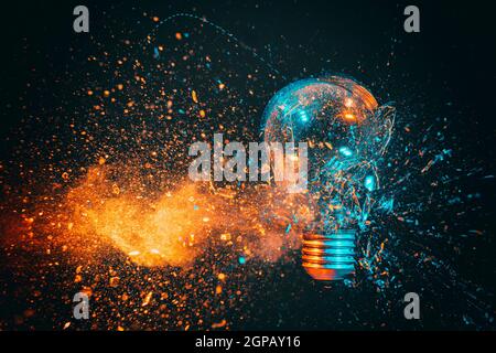 Explosion einer Glühbirne. Schwarzer Hintergrund und blaue und orange Töne. High-Speed-Fotografie. Stockfoto