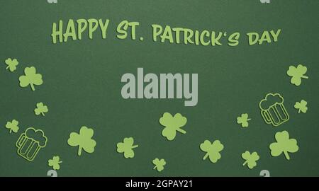 St. Patricks Day Grünpapier Hintergrund mit Papier Kleeblatt und Bierkrug Stockfoto