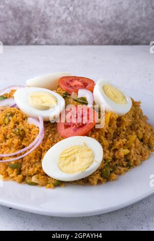 Reisnudelgericht, auch bekannt als String Hoppers biryani mit gekochten Eiern, Tomaten, Zwiebeln und Kerryblättern, sri-lankisches und südindisches Gericht Stockfoto