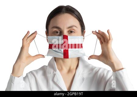 Atemschutzmaske mit Flagge von England Doktor setzt auf medizinische Gesichtsmaske isoliert auf weißem Hintergrund. Stockfoto