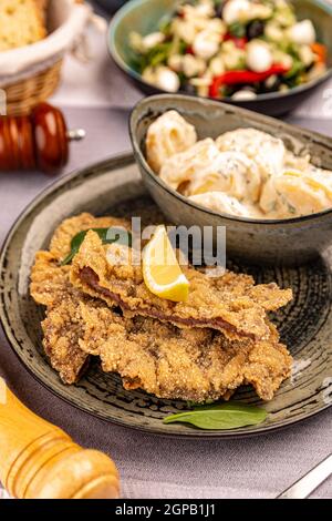 Schnitzel mit Kartoffelsalat auf dem Restauranttisch Stockfoto