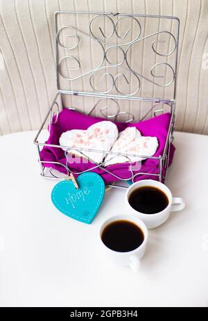 Cookies in einem Herzen und zwei Tassen Kaffee auf den Tisch, dass Zuhause sagt. valentine Karte Stockfoto