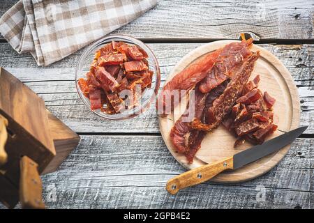 Getrocknetes Hühnerfleisch. Leckeres, ruckiges Fleisch auf einem Holztisch. Draufsicht. Stockfoto