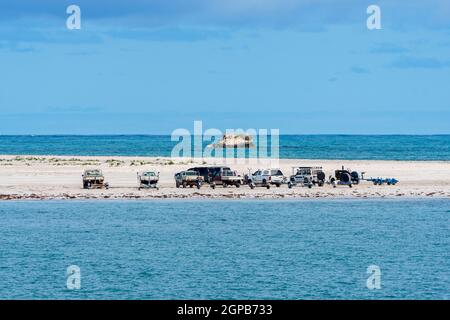 Eine Reihe von Fahrzeugen für Bootsführer und Fischer, die auf einer Sandbank am Strand in der Stadt Cervantes, Western Australia, geparkt wurden Stockfoto