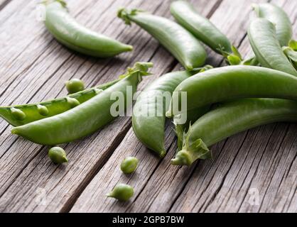 Schnapperbsen auf einem alten Holzbrett platziert. Nahaufnahme, Bild von Schnapperbsen. Stockfoto