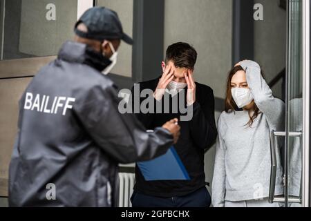 Gerichtsschuldensammler An Der Tür In Maske Stockfoto