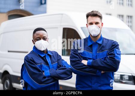 Elektriker Techniker Oder Klempner In Arbeitskleidung Und Gesichtsmaske In Der Nähe Van Stockfoto