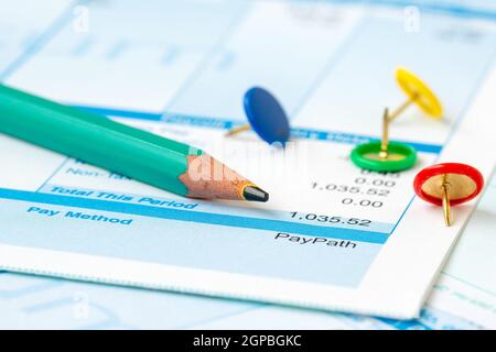 Bleistift und bunten Pins auf Lohn oder Gehalt Hintergrund Stockfoto