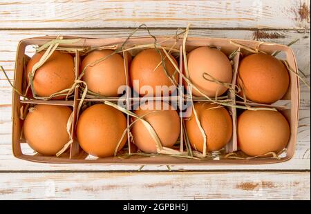 Weideneierschale voll mit frischen Eiern auf einem hölzernen Tabelle Stockfoto