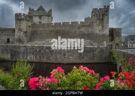 Cahir Schloss aus dem 12th. Jahrhundert mit Graben in Cahir Stadt mit dramatischen, Gewitterhimmel im Hintergrund, Grafschaft Tipperary, Irland Stockfoto