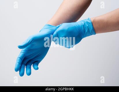 Zwei Hände eines Mannes, der Nitrilhandschuhe auf weißem Hintergrund trägt Stockfoto