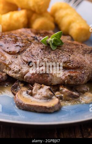 Nahaufnahme eines Schweinesteaks auf Pilzsauce Stockfoto