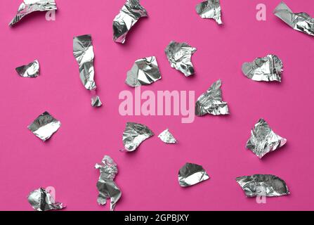 Zerrissene Folienstücke auf rosa Hintergrund, Draufsicht Stockfoto