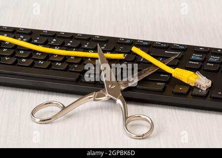 Schere und abgehackte Netzwerk Kabel über PC-Tastatur. Radikale Trennung internet Stockfoto