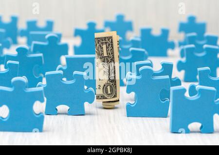 Ein Dollar durch die Puzzleteile umgeben, das Verständnis der Ins und Outs zu investieren. Stockfoto