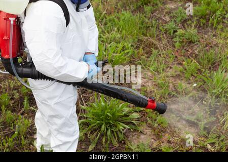 Arbeiter in Schutzanzug Spray Desinfektionsmittel während der Coronavirus-Pandemie. Desinfektions- und Dekontaminationskonzept. Stockfoto