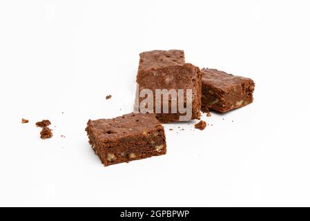 Gebackene Schokolade Brownie Stücke mit Walnuss auf weißem Hintergrund, leckeres Dessert Stockfoto