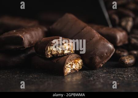 Schokoriegel mit Nußfüllung auf schwarzem Tisch. Stockfoto