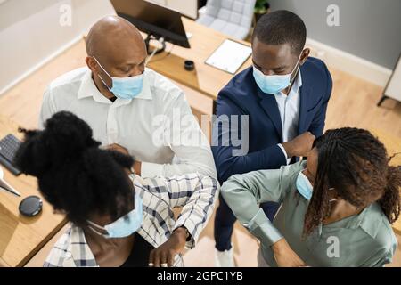 Ellenbogen In Maske Im Büro. Afrikanische Geschäftsleute Stockfoto