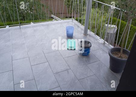 Fliesenleger Verlegung Fliesen auf dem Boden von einem Balkon und verfugt. Stockfoto