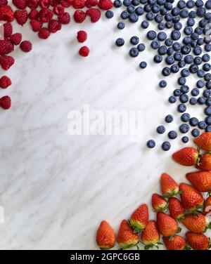 Stillleben mit Heidelbeeren, Erdbeeren und Himbeeren auf weiß gemustertem Hintergrund Stockfoto