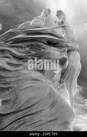 Statue einer Frau mit nach oben ausgestreckten Armen. Frieden, Freiheit, Osterkonzept und mehr. Stockfoto