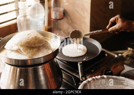 Idli oder untätig, herzhafter Reiskuchen aus Indien, Frühstücksspeisen im Süden. Frau, die zu Hause kocht, warme Speisen mit Dampf Stockfoto