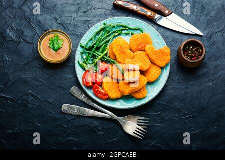 Köstliche gebratene Hähnchennuggets mit Kuhpfeiben auf dem Teller Stockfoto