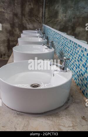 Reihe von Wasserhahn mit Wassertropfen auf der Vorderseite Stockfoto