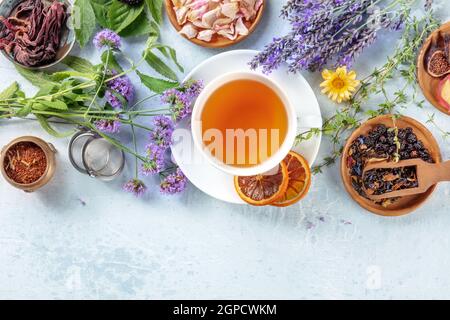 Tee, Overhead-Aufnahme mit Kopierplatz. Kräuter, Blumen und Früchte um eine Tasse Tee Stockfoto