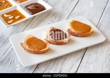 Sandwiches mit verschiedenen Karamellsorten auf dem Servierteller Stockfoto