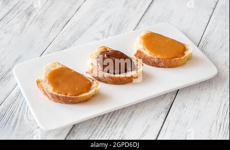 Sandwiches mit verschiedenen Karamellsorten auf dem Servierteller Stockfoto