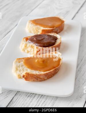 Sandwiches mit verschiedenen Karamellsorten auf dem Servierteller Stockfoto