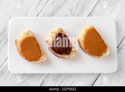 Sandwiches mit verschiedenen Karamellsorten auf dem Servierteller Stockfoto