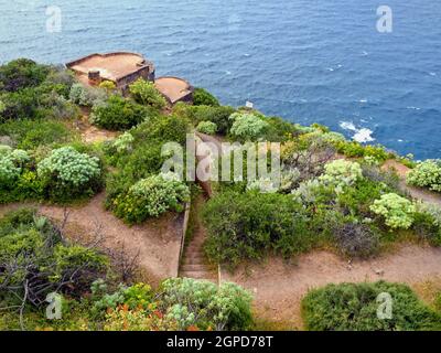 Blick von oben auf einen alten verlassenen, fast überwuchert Bunker an der Steilküste im Norden der Insel Teneriffa in La Quinta. Hinter dem blauen an Stockfoto