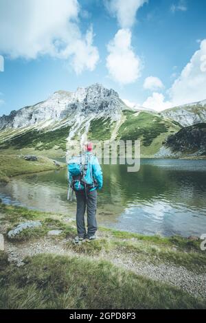 Weibliche blond Bergsteiger mit Rucksack ist die Aussicht genießen Stockfoto