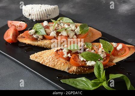 Caprese Bruschetta Toasts mit Kirschtomaten, Mozzarella und Basilikum. Stockfoto