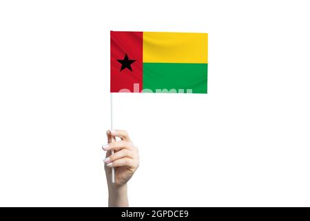 Schöne weibliche Hand hält Guinea-Bissau Flagge, isoliert auf weißem Hintergrund. Stockfoto