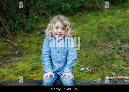 Kleines Kind mit langen blonden Haaren und einer sonnigen Tag Stockfoto