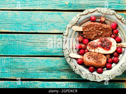 Eis auf Stöcken mit Schokolade.Schokoladenüberzogene Eis mit Kirschmarmelade Stockfoto