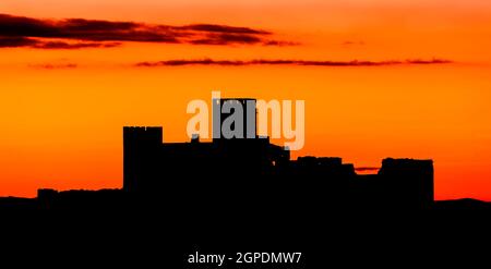 Silhouette einer erstaunlichen Burg über einem roten Himmel Stockfoto