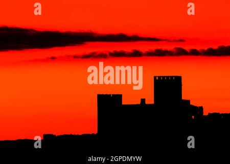 Silhouette einer erstaunlichen Burg über einem roten Himmel Stockfoto