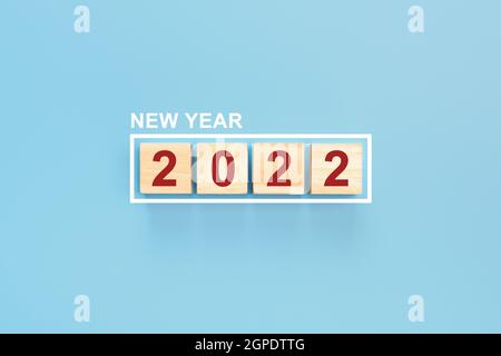 Happy New Year 2022 Hintergrund. Holzwürfel in einem Rahmen mit dem Text 2022 auf blauem Hintergrund. Kann für, Landing Page, Vorlage, ui, Web, Mobile AP Stockfoto