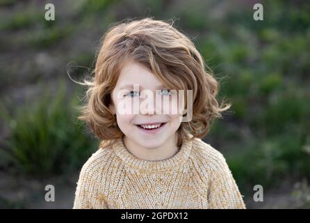 Glückliches blondes Kind mit gelbem Trikot an einem sonnigen Tag Stockfoto