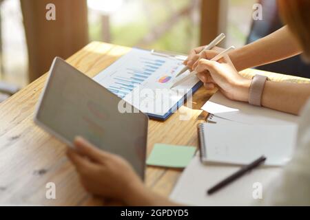 Nahaufnahme von zwei leitenden Unternehmern, die zusammen an Tablets arbeiten und Berichte erstellen. Brainstorming und Teamwork-Konzept Stockfoto